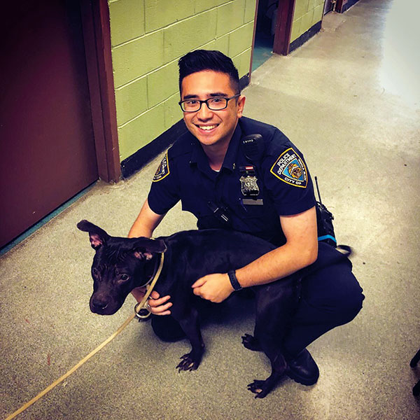Officer Hoza in his Precinct with Autumn, an abused pup he adopted. Courtesy of Paul Hoza.