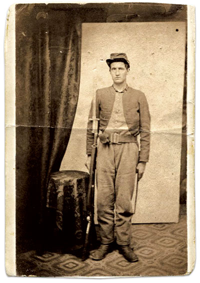 This unidentified Zouave of the three-year regiment wears the second-pattern uniform acquired by December 25, 1861, consisting of a dark blue jacket with integral, light blue, buttoned false vest, regulation sky blue infantry trousers, and plain dark blue cap. He holds a Model 1855 rifle, also known as the Harpers Ferry rifle, with sword bayonet, and a pattern 1855 rifleman’s belt. Carte de visite by an unidentified photographer. Dan Miller Collection.