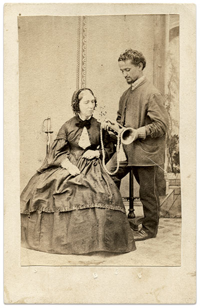 Ransom may have sat for this portrait during her convalescence following the North America disaster. The man standing next to her, possibly a soldier or an attendant, presents a bugle for her inspection. A sword leans against the wall behind her. The meaning of this scene has been lost in time. The stamp on the back of the card stock mount suggests she sold copies of her likeness to raise money for philanthropic efforts. Carte de visite by an unidentified photographer. The Liljenquist Family Collection at the Library of Congress.