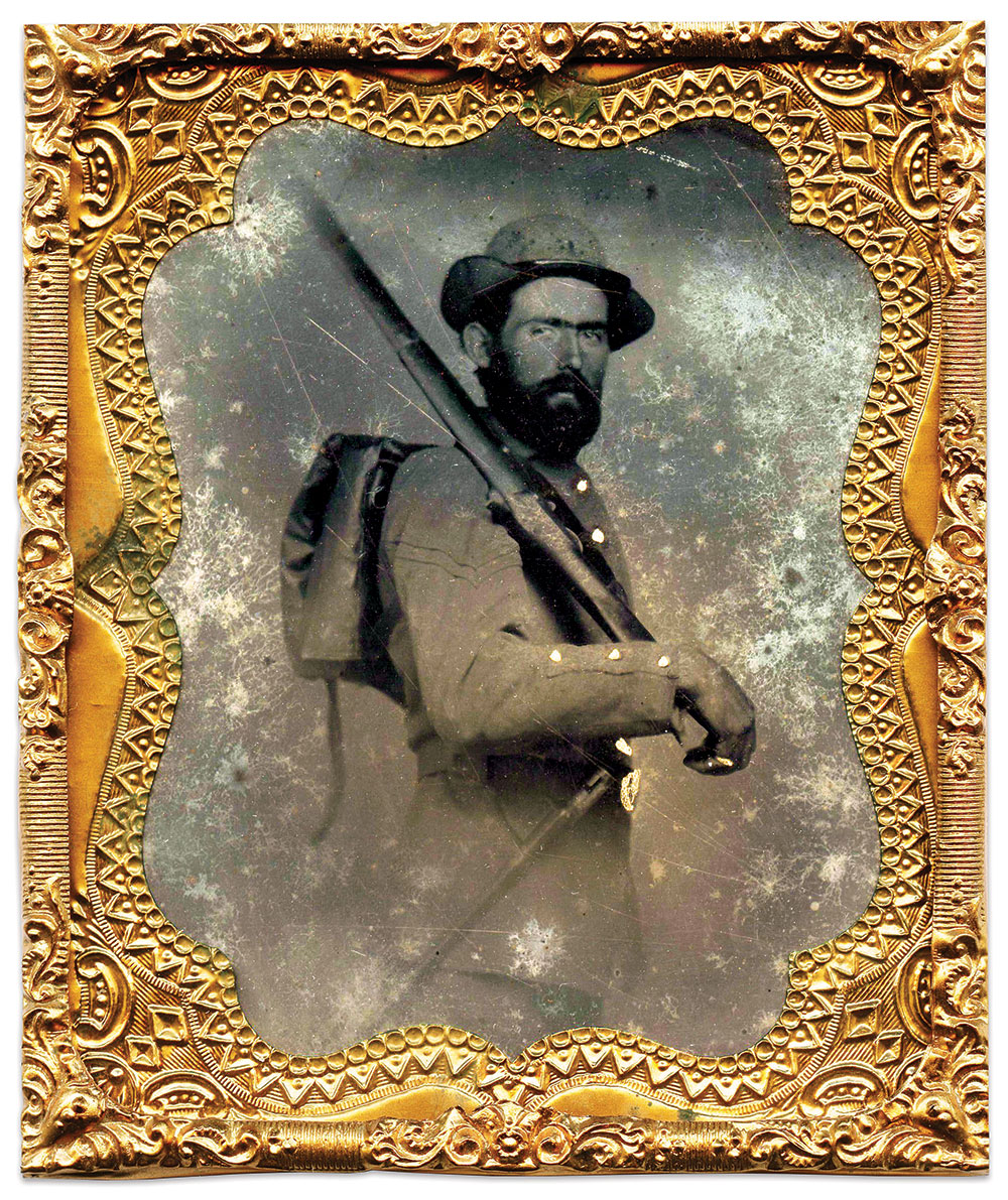 An unidentified corporal, believed to be an Iowan, appears battle-ready in this unusually posed image. A company letter is attached to the front of his Havelock hat. He has a semi-rigid knapsack strapped to his back and an 1855-pattern bayonet and scabbard attached to his waist belt. He shoulders a U.S. conversion musket. Sixth-plate tintype by an anonymous photographer. David Rowland Collection.